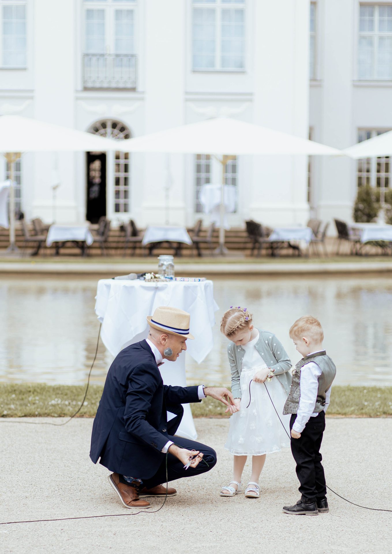 zwei Kinder helfen dem Trauredner bei einem Hochzeitsritual