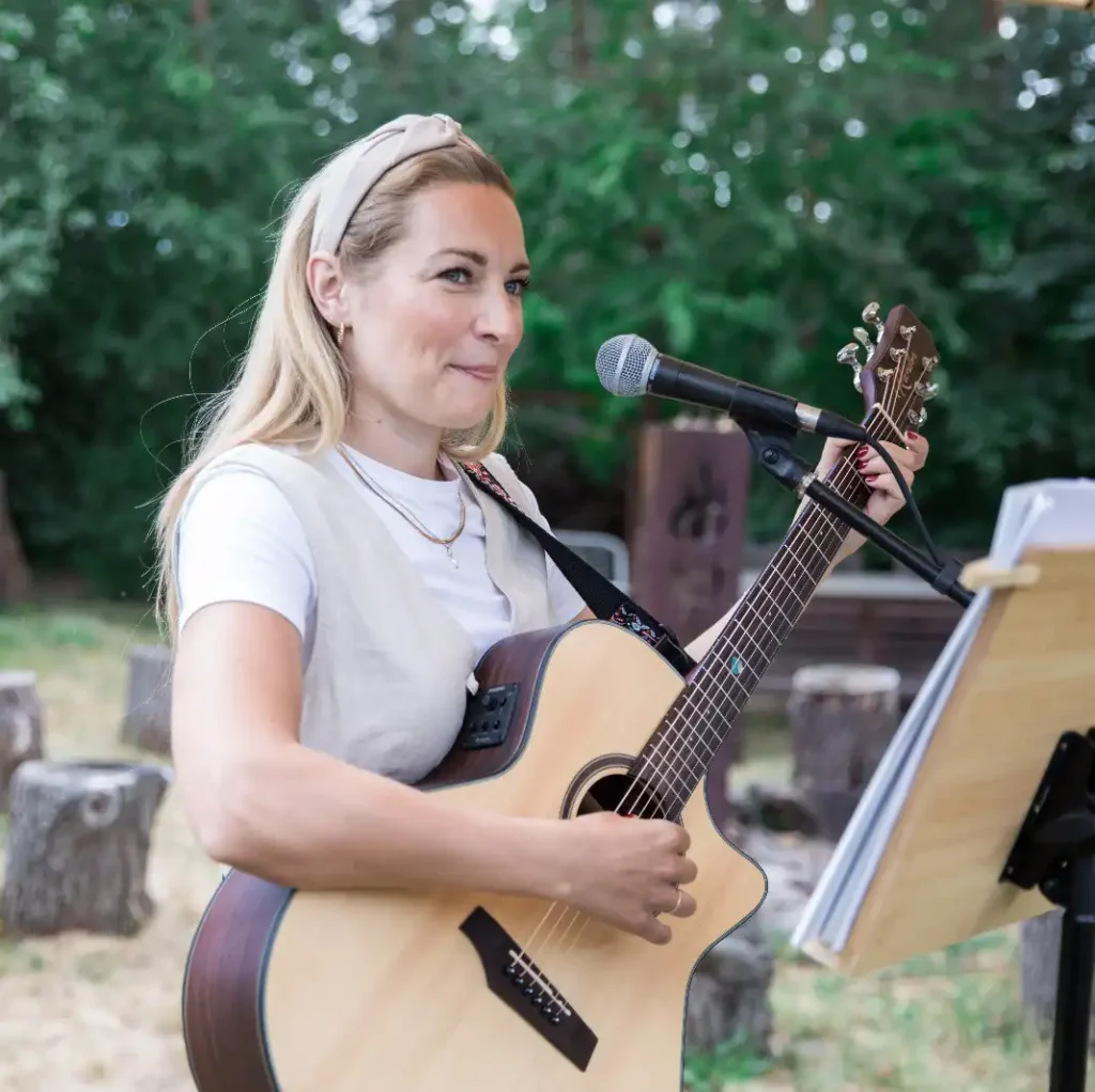 Frau mit Gitarre und Mikrofon