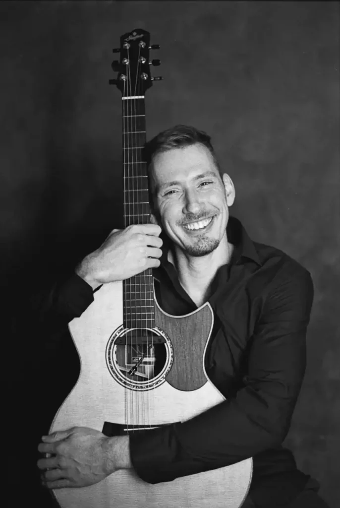 Mann mit Gitarre und Lächeln