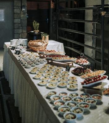 Hochzeitsbuffet mit
regionalen Vorspeisen in
kleinen Schälchen zur
Vermeidung von Food
Waste bei einer Hochzeit.